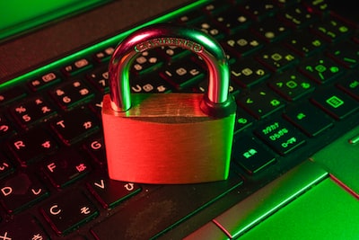 Red padlock on a black computer keyboard representing WordPress website security hardening and cyber protection